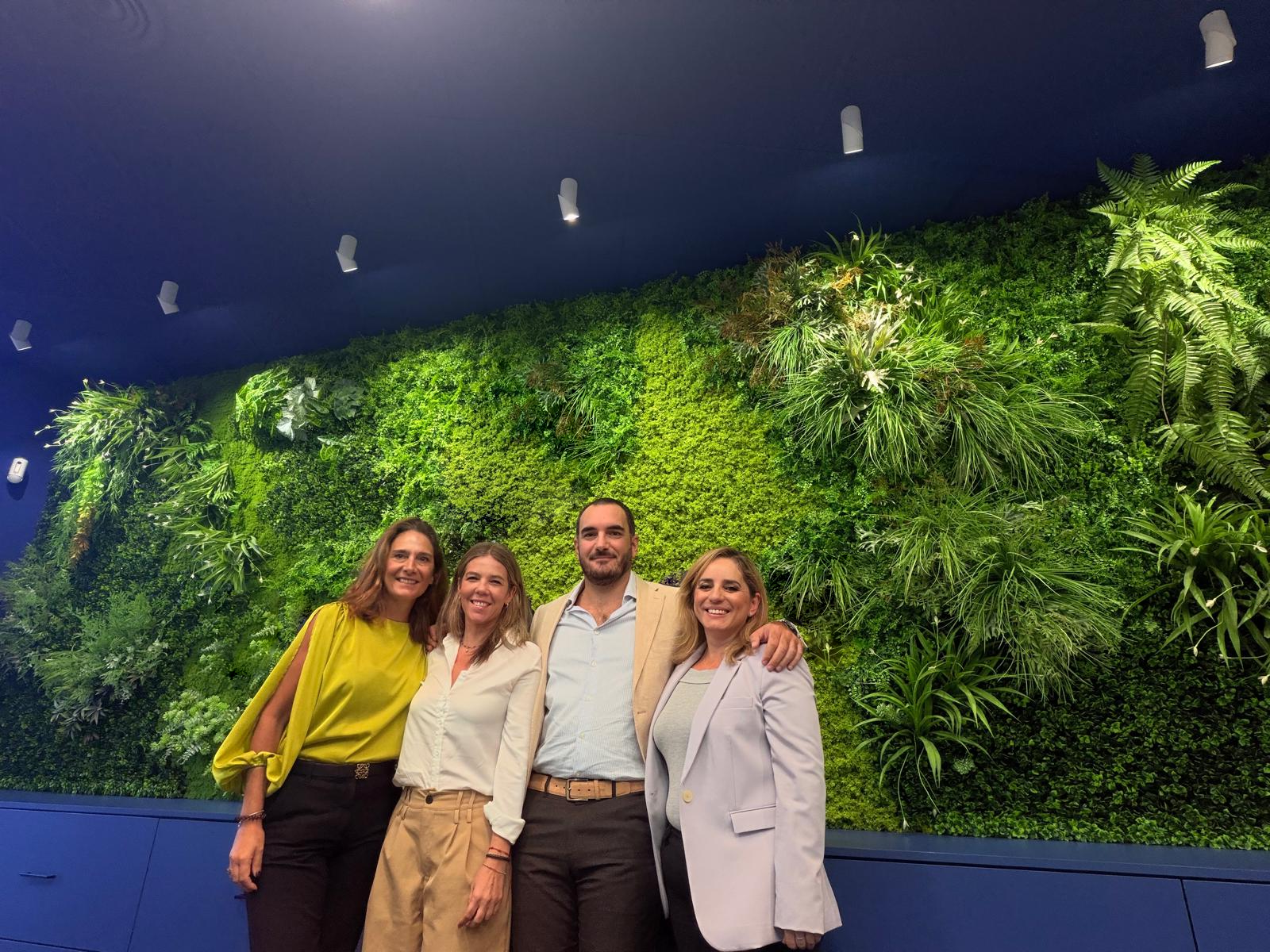 Four members of the Grupo Endurance team in front of a living wall